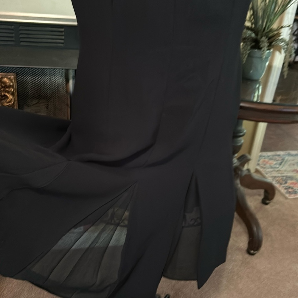 Cut black dress with pleats and sheer material between the pleats